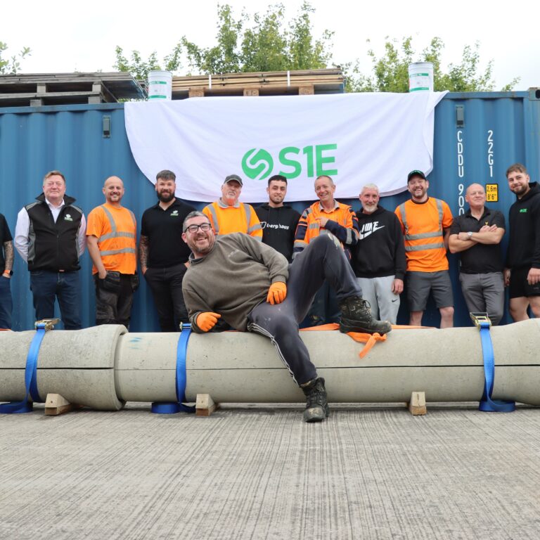 S1E staff standing behind a length of pipe