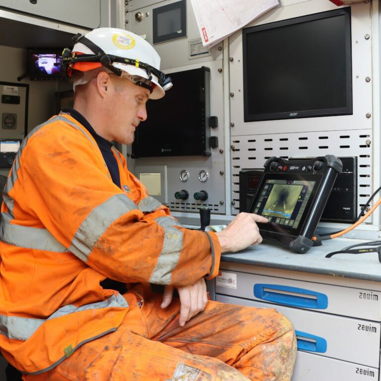 man in hi-viz PPE using computer monitor